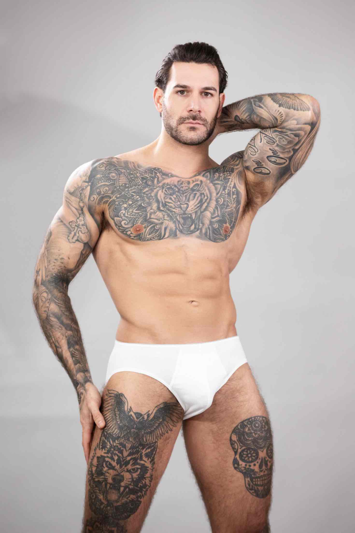 Papi Kocic showcasing his athletic 6'3 frame and muscular build in a high-quality fitness photography session, highlighting his brown hair and intense gaze.