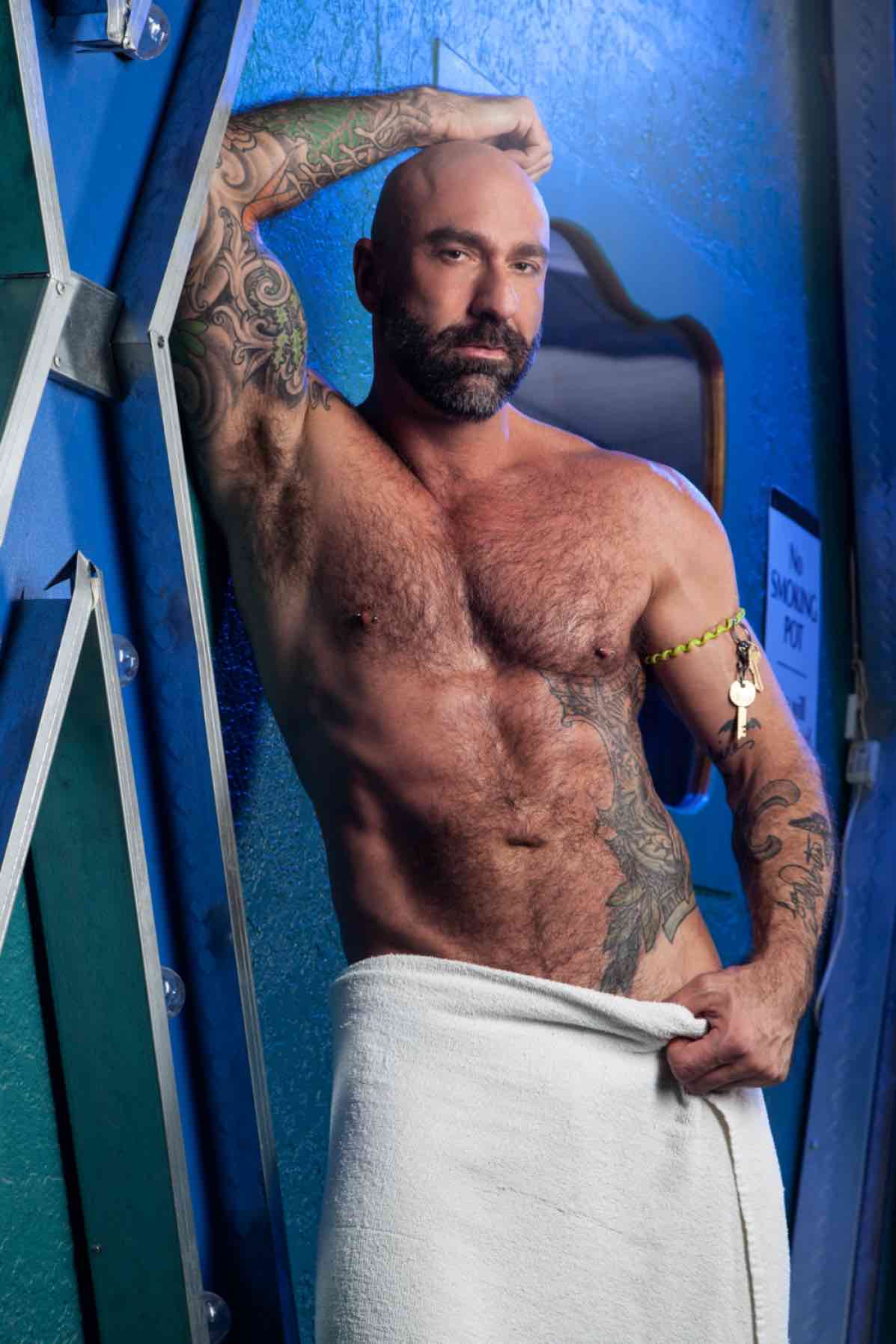 Drew Sebastian in a sophisticated studio setting, showcasing his silver hair, blue eyes, and 6'2 inch athletic frame for a professional profile shot.